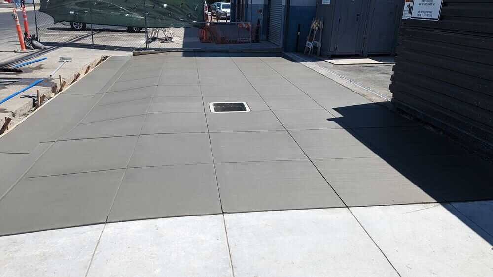 Freshly poured commercial concrete flatwork pad with drain
