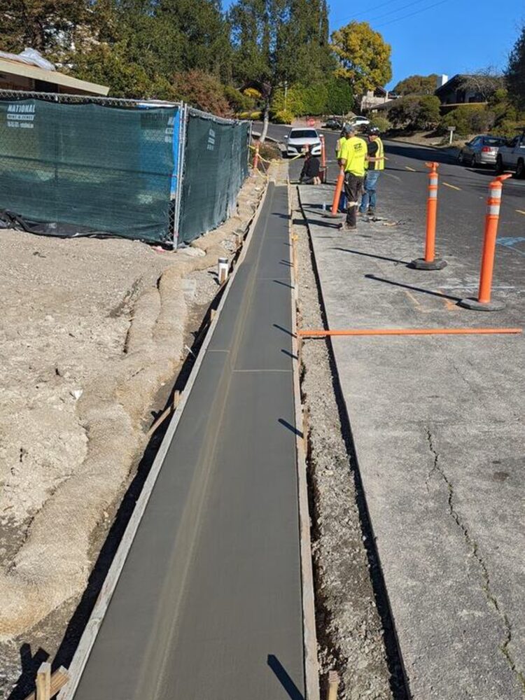 Structural concrete retaining wall with curb formwork on a commercial site